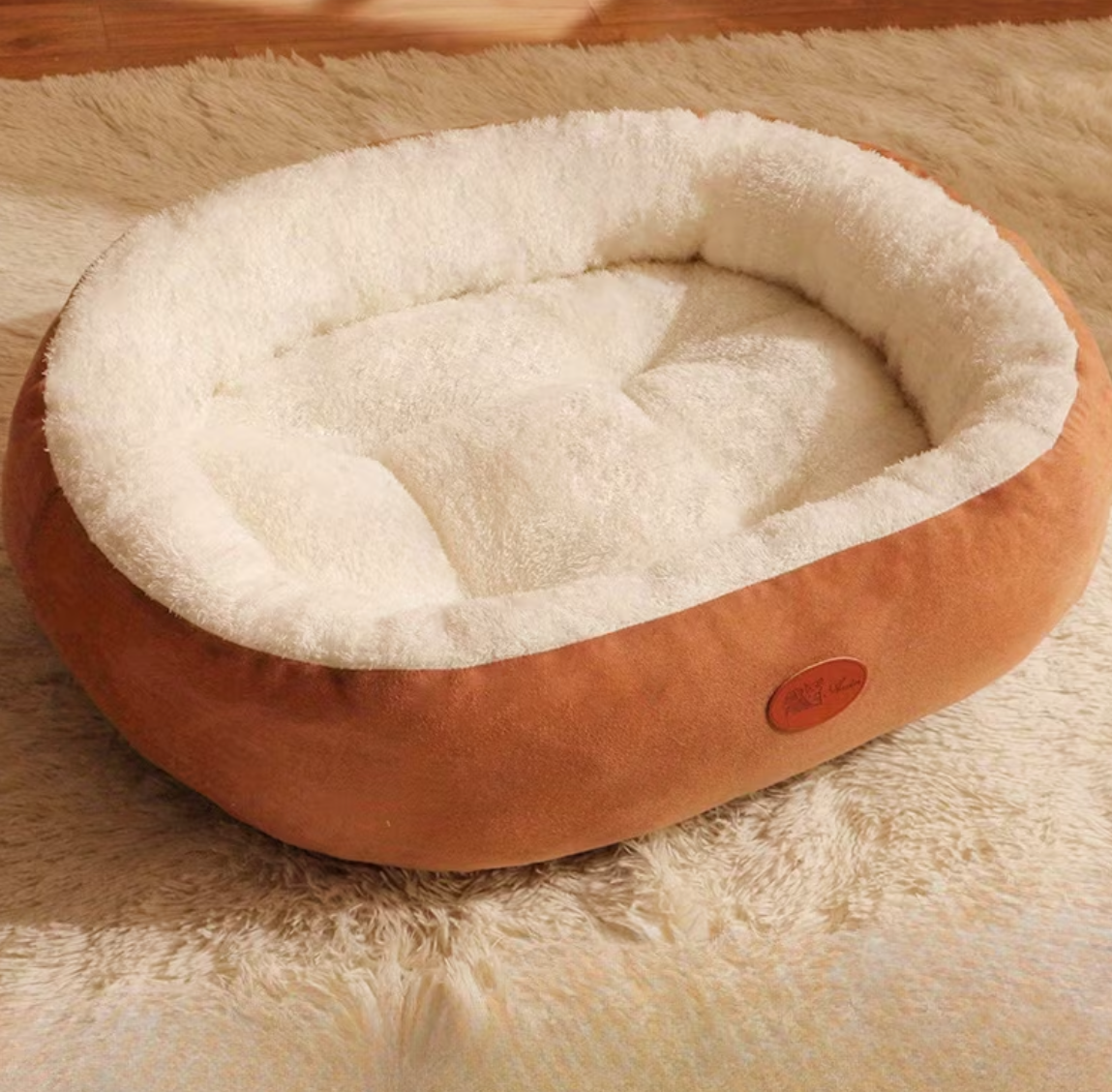 Round pet bed with beige cushion on a textured surface